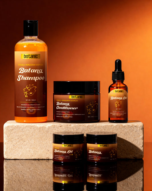 Collection of Botanic Batana hair care products on a stone surface with an orange background