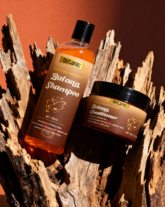 Botanic Batana Shampoo and Conditioner bottles on a wooden background