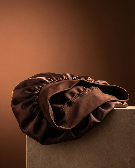 Brown satin hair cap on a neutral background